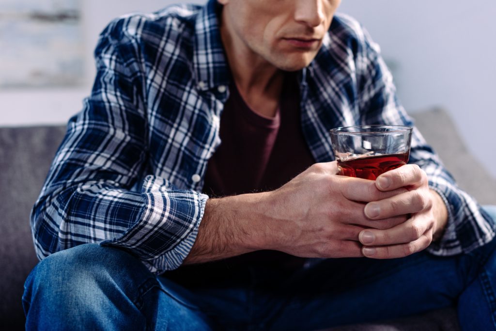 Man drinking alcohol on sofa