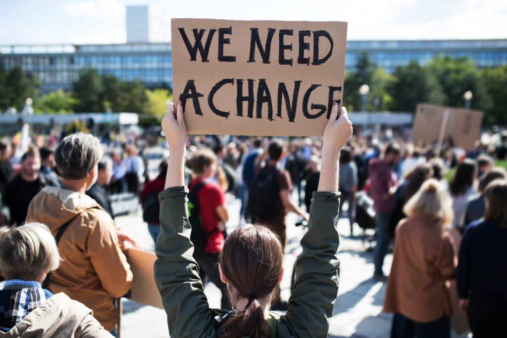 Rally with sign: We Need a Change