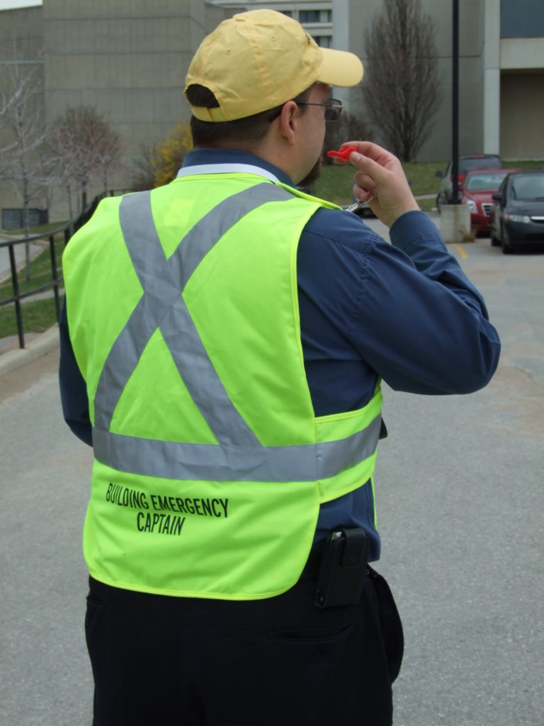 Photo of building emergency captain in a bright yellow hat and vest