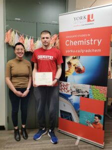 Professor Le and Alex Akhundov standing with the certificate awarded by the American Chemistry Society (ACS), Organic Chemistry Division