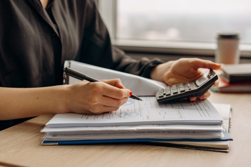 woman holding a calculator and a pen