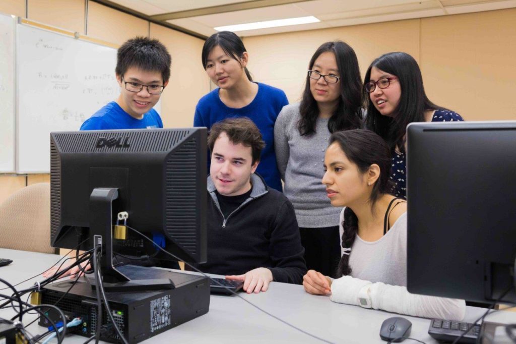 students crowded around a computer