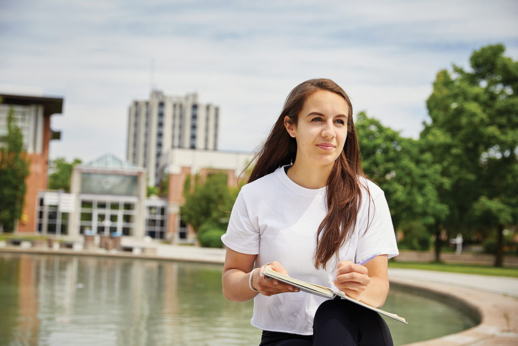 Female student sitting outside reading