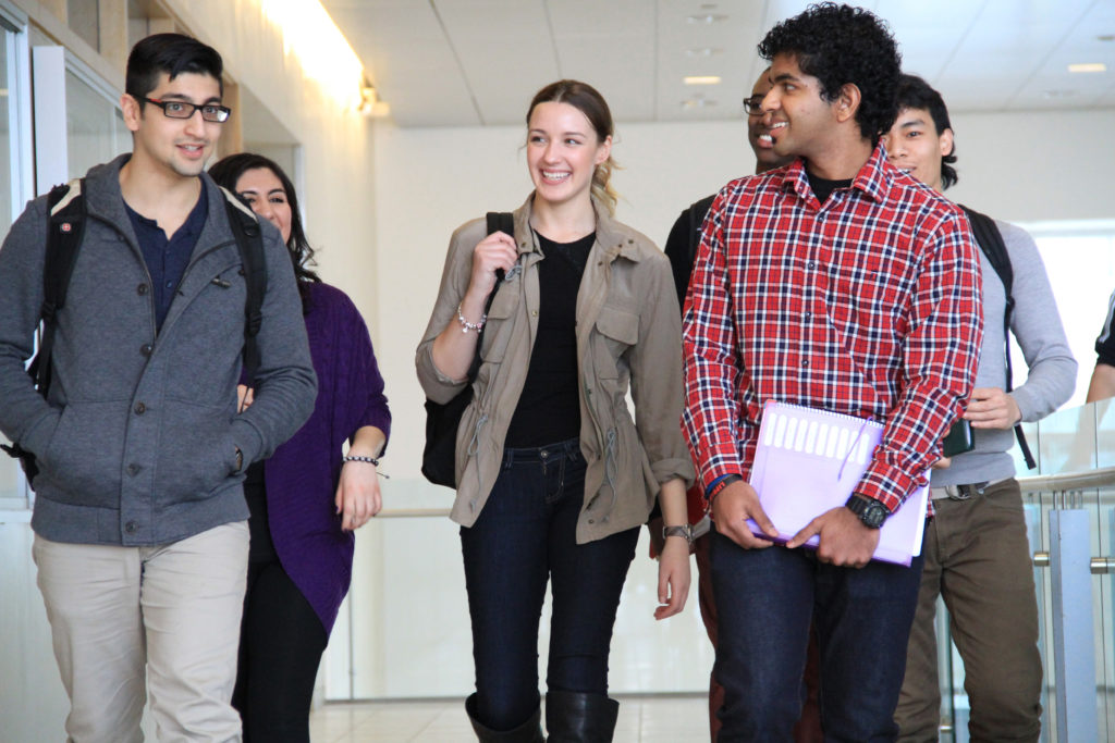 Students walking in a hallway on campus.