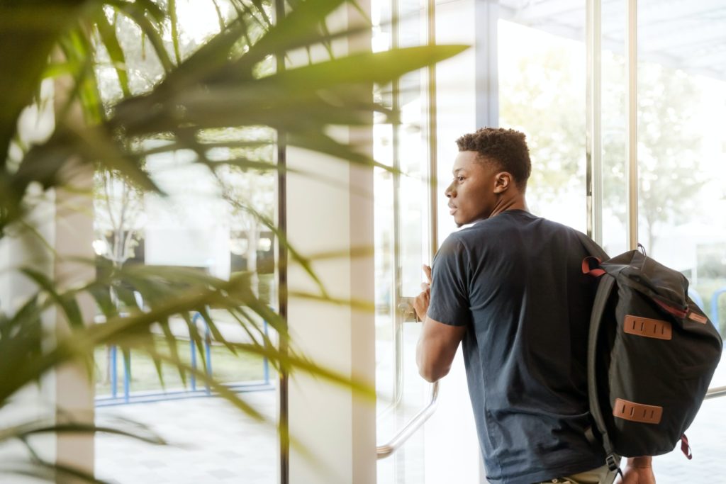 Student pushing door to go outside.