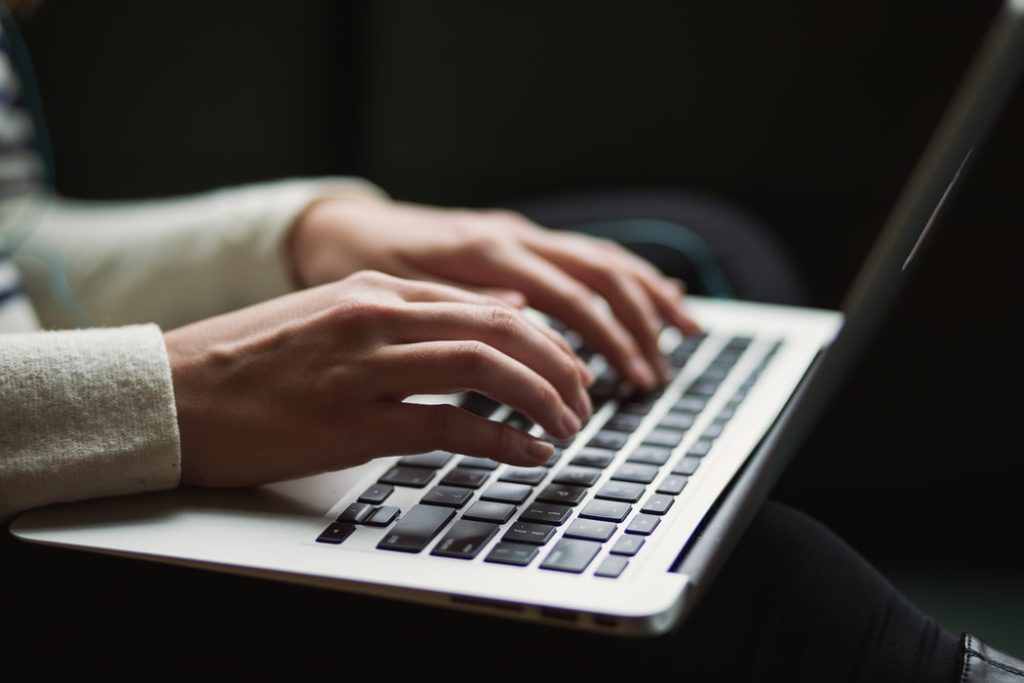 Hands typing on computer.