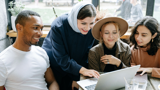 group of students looking at a laptop