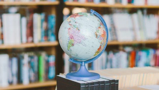 A plastic globe on a stack of books