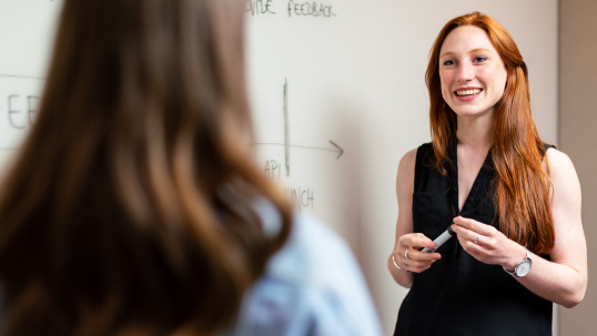 Woman teaching in front of a whiteboard