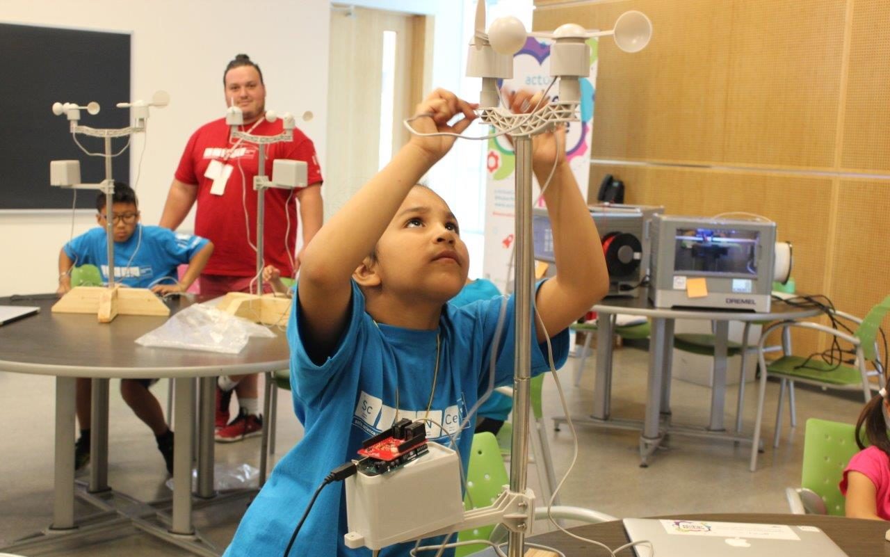 Young boy building a structure at science camp