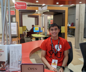 A Learning Skills Peer sits at the red welcome desk on the second floor of Scott Library.
