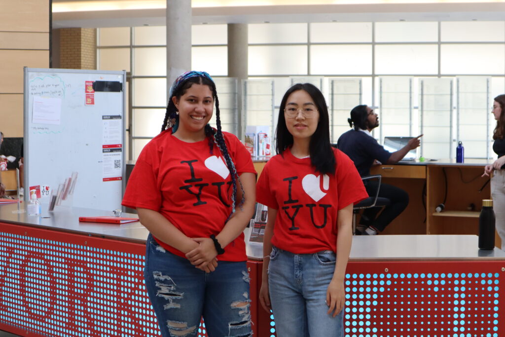 Two Learning Skills Services peer pose in front of the kiosk in Vari Hall