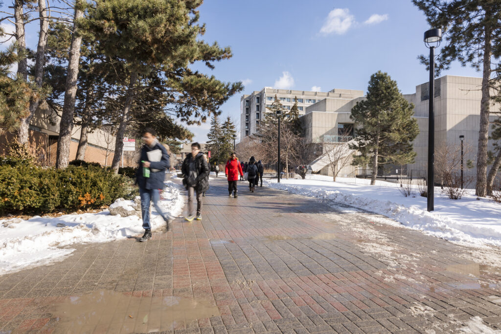 Students walking across Keele campus on an early spring day.