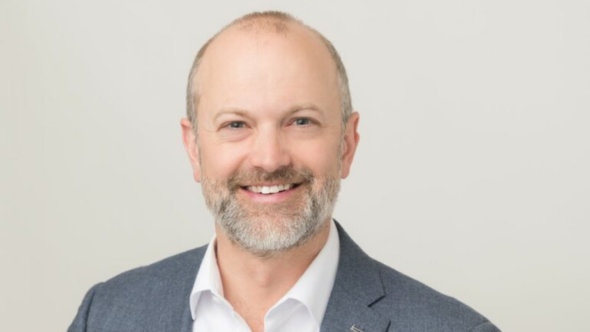Profile photo of Mike Layton wearing a grey suit jacket with white collared shirt while smiling at the camera