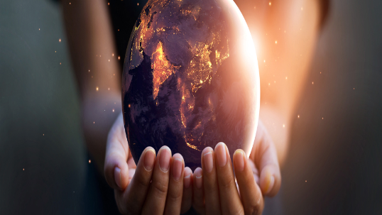 Person holding glowing globe of earth in hands