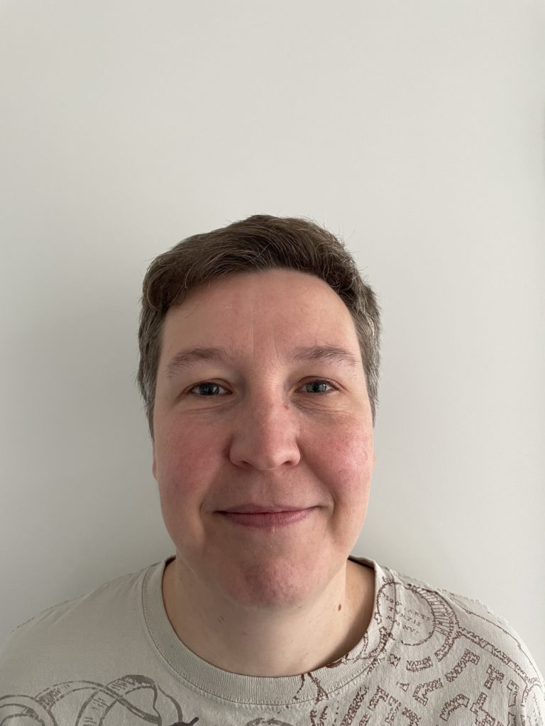 Valérie Florentin smiling into the camera in front of a grey background