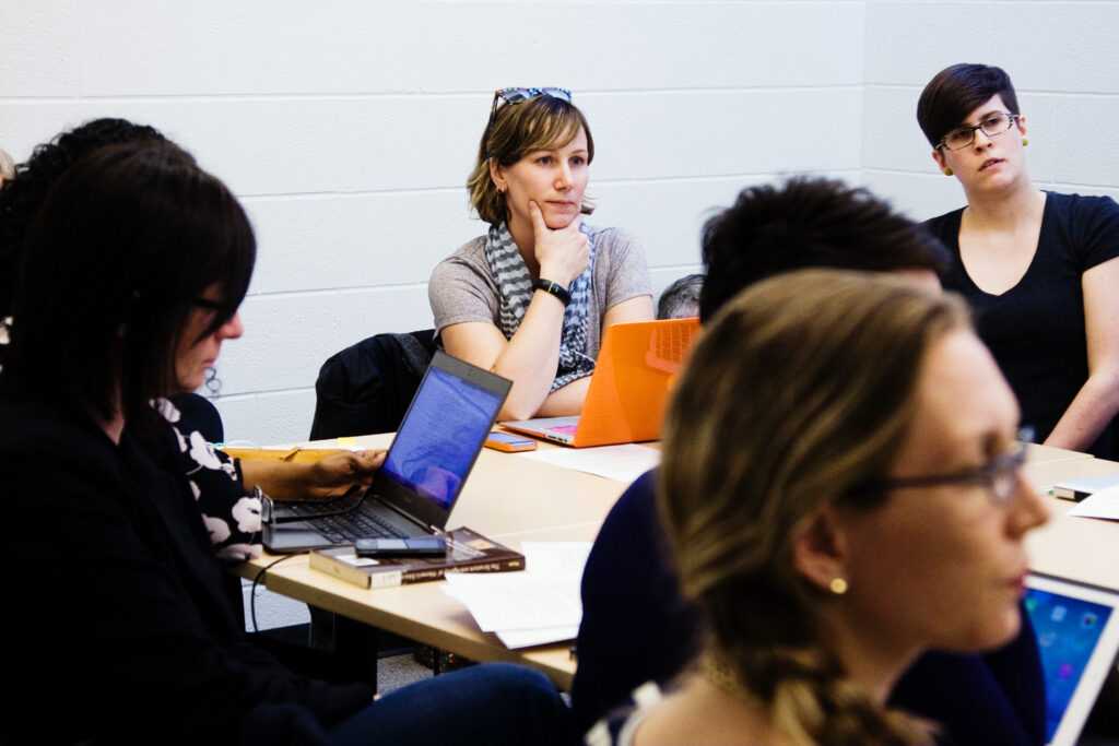 A group around a desk listening to a speaker