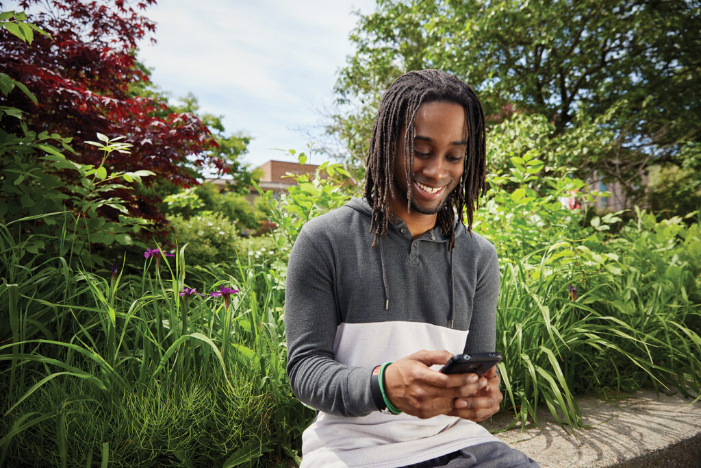 Black man engaging on his phone in nature