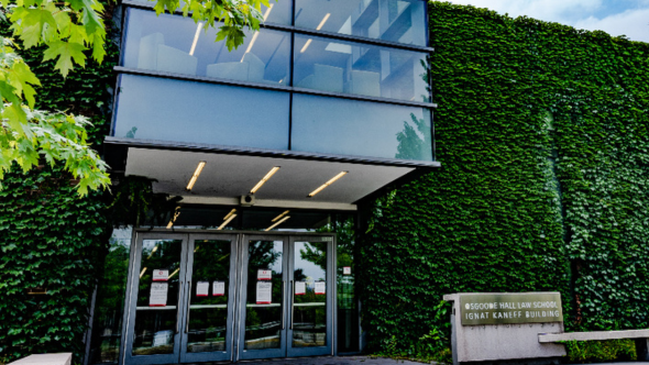 The front entrance of Osgoode Hall Law School with glass doors and greenery growing on the walls