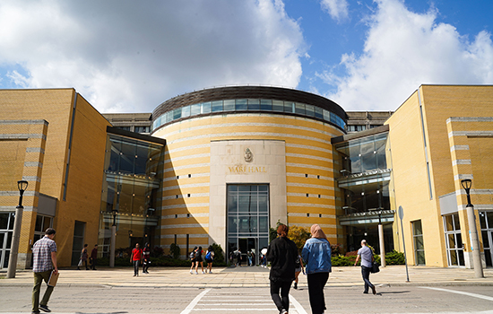 Exterior shot of Vari Hall with students walking towards the building.