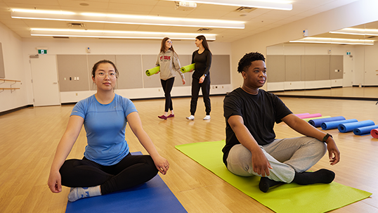 Students practice yoga indoors