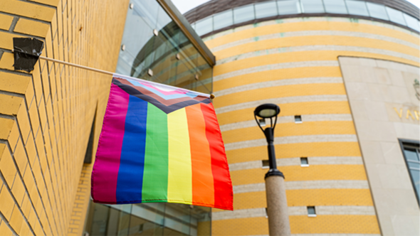 Small Pride Flag hanging from side of building at Vari Hall