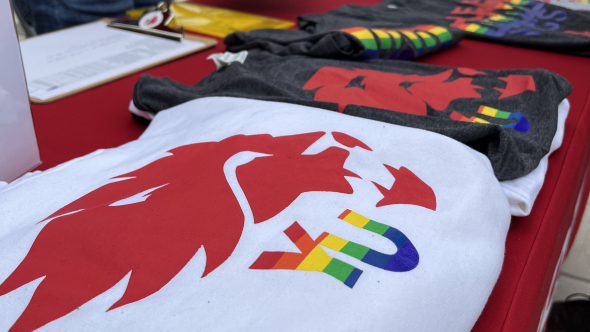 Shirts folded on tale with York Lions logo. The YU letters are in Pride rainbow colours
