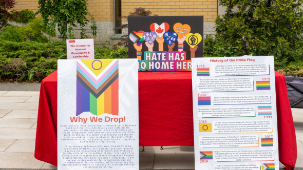 A table with various pieces of signage about Pride Month